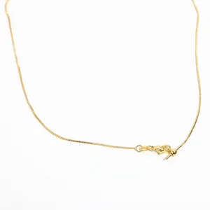Macro detail of adjustable gold box chain necklace with needle pin and lobster clasp