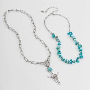 Detail of vintage turquoise beaded necklace set with longhorn skull pendant and silver beads