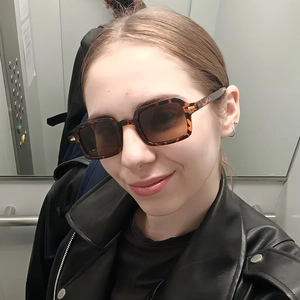 Detailed view of vintage square tortoiseshell sunglasses worn with a black leather jacket
