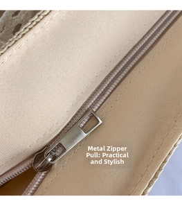 Detail view of silver metal zipper pull and premium stitching on beige woven bag