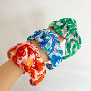 Detailed view of printed knotted headbands featuring floral and plant textile patterns