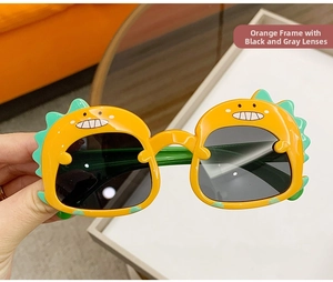 Detailed close-up of cartoon dinosaur sunglasses with orange frames and dark gray lenses