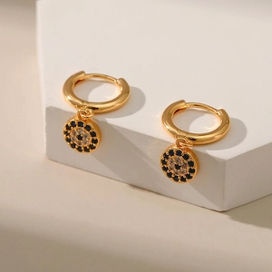 Detail of gold evil eye hoop earrings with cubic zirconia on minimalist stand