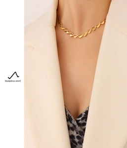 Detail einer goldenen Edelstahl-Halskette mit Blatt- und Herzform-Kette am Modell