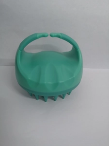 Detail view of the ergonomic handle and flexible silicone bristles of the green scalp brush