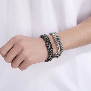 Detail of silver and gunmetal gray double-layer stainless steel Cuban chain bracelets