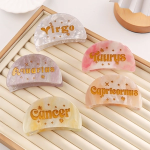 Set of constellation hair clips in marble acetate finish displayed on a beige tray