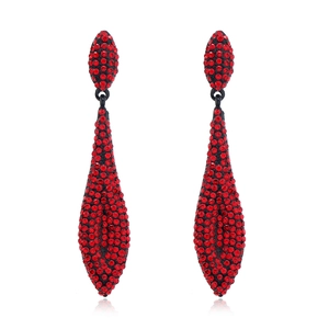 Close-up of luxury red rhinestone teardrop earrings with black metal finish and reflection