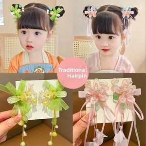Detail view of pink and green traditional tassel hair clips with flowers and ribbons