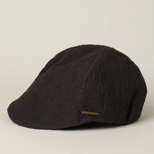 Detailed texture of dark brown linen newsboy cap with a premium metallic logo buckle