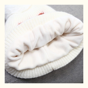 Close-up of soft thick fleece lining inside the white knitted winter hat for kids