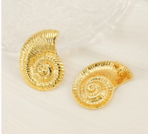 Macro shot of 18K gold plated conch shell earrings with detailed spiral texture
