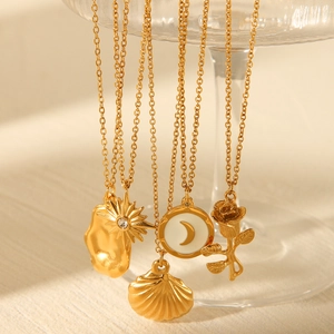 Detail of five gold stainless steel necklaces with rose, star, and shell pendants