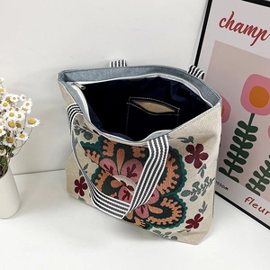 Vintage embroidered floral canvas tote bag with striped handles and zipper closure