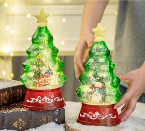Detail of Christmas tree water globe with Santa and snowman inside a red base