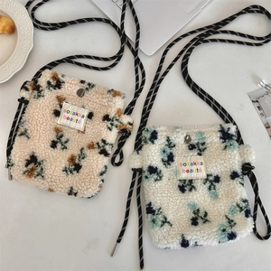 Detailed view of plush rainbow polka dot bags with braided straps and metal snap closure