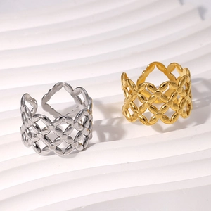 Close-up of gold and silver hollow lattice rings with star patterns on a white tray