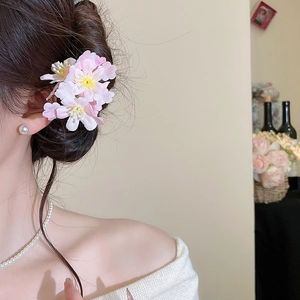 Detail view of a pink floral hair stick with gradient petals and 3D fabric flowers