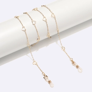 Golden hollow heart metal glasses chain draped on a cylinder pedestal with non-slip loops