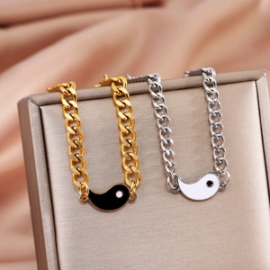 Detail of Yin Yang Tai Chi pendant bracelets on a gold luxury jewelry box and silk