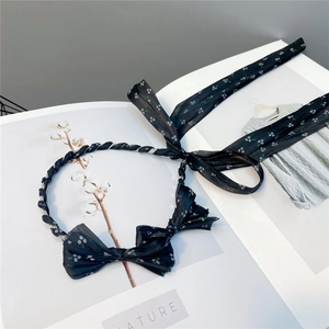 Detail of black polka dot bow headband with long chiffon ribbons on a fashion magazine