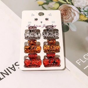 Detail view of 6-piece mini bow hair claws set in tortoiseshell patterns and colors