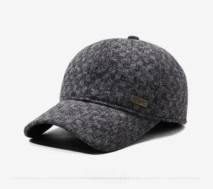 Detailed side view of gray herringbone wool baseball cap with metallic logo badge