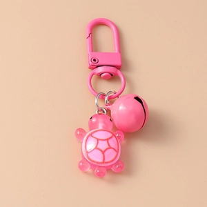 Close-up of pink resin turtle keychain featuring a metal hook and matching pink bell