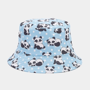 Detail of light blue bucket hat with cute panda patterns and white polka dots on cotton fabric