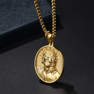 Macro close-up of golden oval Jesus pendant with detailed relief and square chain link
