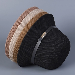 Close-up of four knitted sun hats in different colors showing texture and metal buckles