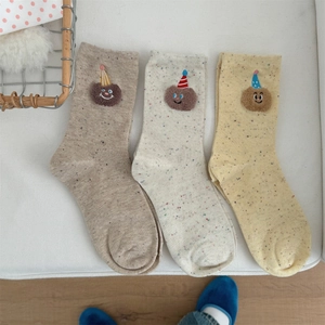 Detailed view of socks featuring cartoon bear embroidery with colorful speckled knit fabric