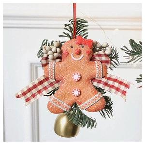 Macro view of gingerbread man ornament with red bow, pine branch and golden bell