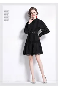 Close-up of elegant black dress featuring lace sleeves and cinched waist detailing