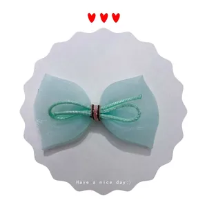 Detail of mint green mesh bow hair clip with pink striped tie and sweet style design