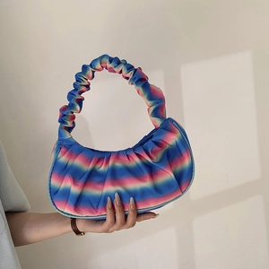Close-up of blue and pink gradient pleated shoulder bag in crescent shape and satin texture
