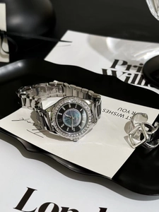 Detail of silver women's watch with mother-of-pearl dial and crystal bezel