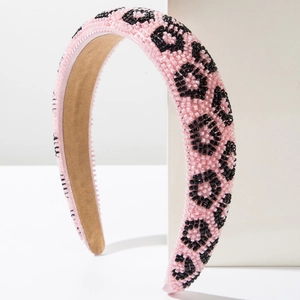Detailed view of handmade pink beaded headband featuring black leopard pattern beadwork