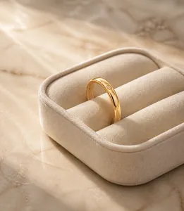 Close-up of minimalist gold ring with a single small crystal on model's finger