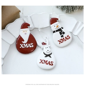 Detailed view of resin Santa, snowman and reindeer ornaments on a white vintage plate