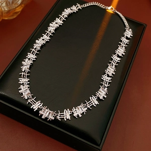 Close-up of silver geometric chain necklace with zircon crystals on black jewelry box