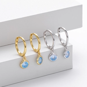 Detailed view of S925 sterling silver hoop earrings with round light blue gemstones