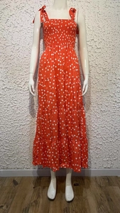 Detail of red polka dot maxi dress with bow shoulder straps and tiered skirt design