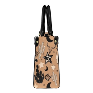 Side view of tan PU tote bag featuring Western cactus and skull prints with black handles