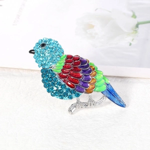 Spilla a forma di uccello colorato con cristalli blu e piume in smalto su base argento