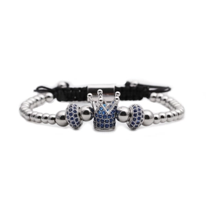 Detail of silver crown charm with blue zircon stones on black braided adjustable bracelet