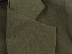 Gros plan détaillé montrant la texture et les coutures du tissu de blazer vert olive