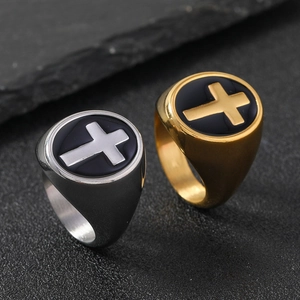 Macro view of gold and silver signet rings with a 3D cross pattern on black base