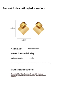 Detail view of geometric brushed gold earrings with size measurements and specifications