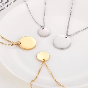 Colliers à pendentif disque rond en or et argent sur une assiette blanche épurée